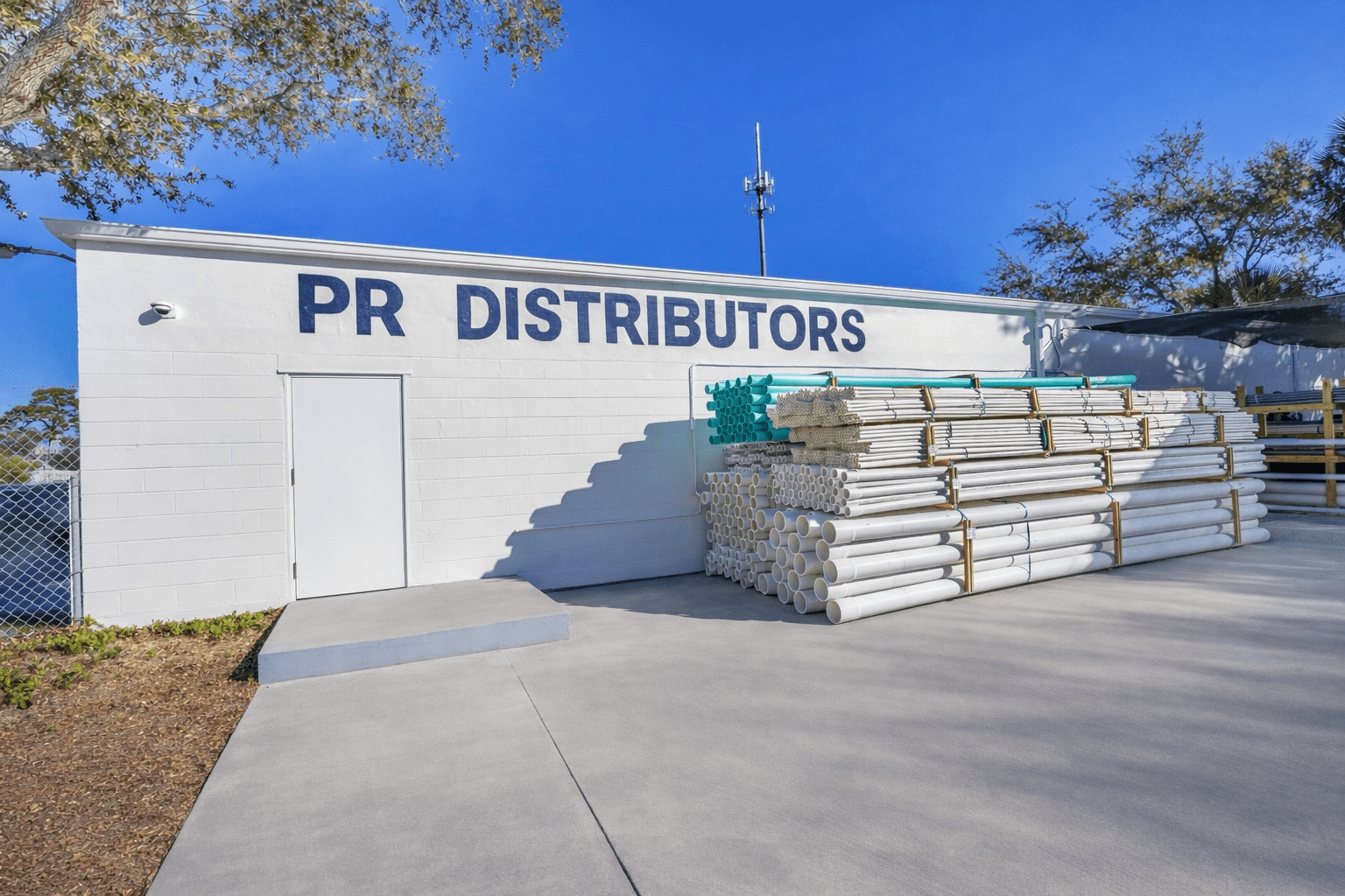 Exterior view of PR Distributors building with pipes.