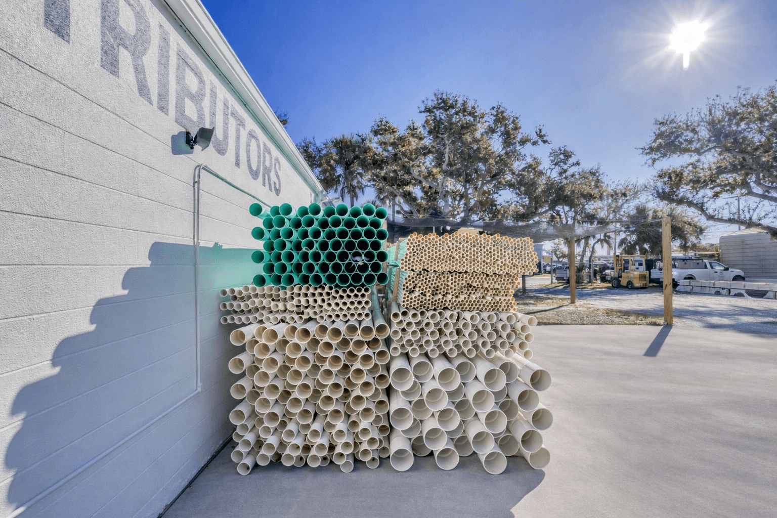 Stacked industrial pipes outdoors on a sunny day.