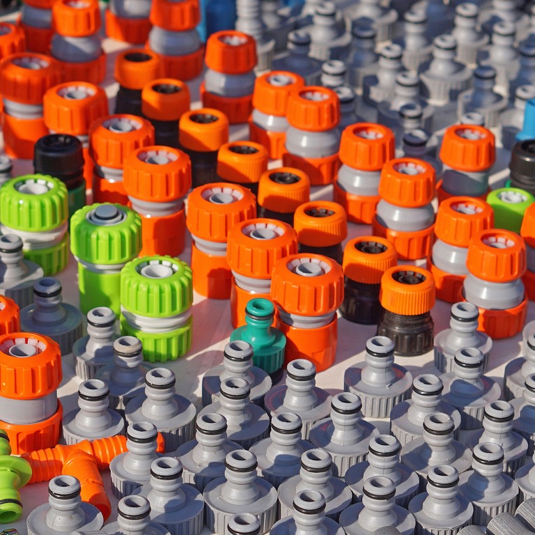 Colorful plastic garden hose connectors on display.